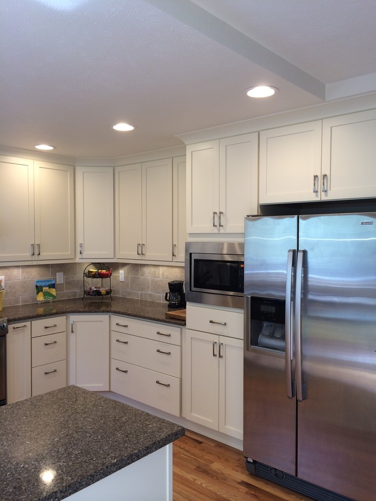 Example of a kitchen design in Denver with recessed-panel cabinets, white cabinets, gray backsplash and stainless steel appliances