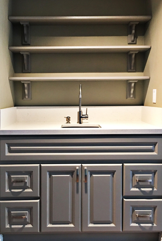 Example of a mid-sized transitional u-shaped medium tone wood floor eat-in kitchen design in Orange County with raised-panel cabinets, gray cabinets, quartz countertops, a peninsula, a single-bowl sink, white backsplash, stone slab backsplash and stainless steel appliances