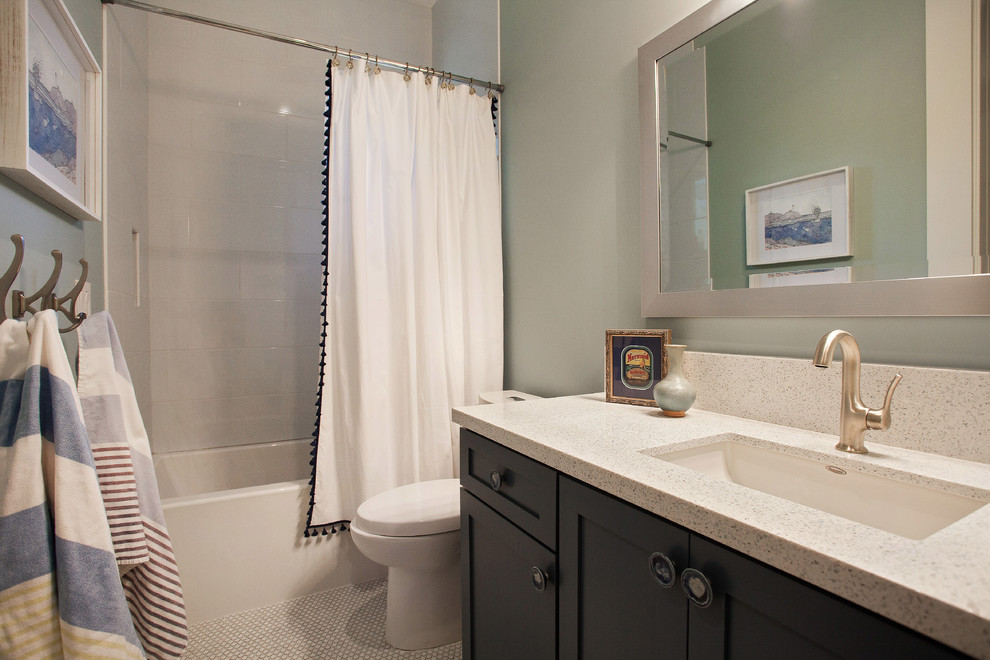 This is an example of a mid-sized country bathroom in San Francisco with an undermount sink, recessed-panel cabinets, engineered quartz benchtops, white tile, porcelain tile, green walls, ceramic floors, an alcove tub, a shower/bathtub combo, a two-piece toilet and black cabinets.