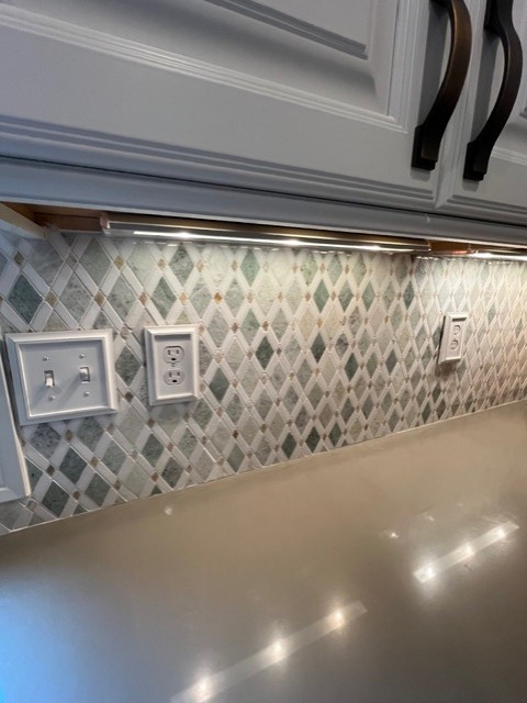 Example of a large transitional u-shaped eat-in kitchen design with raised-panel cabinets, white cabinets, quartz countertops, green backsplash, mosaic tile backsplash, stainless steel appliances, an island and green countertops