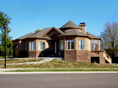 Inspiration for a large timeless beige two-story stucco exterior home remodel in Denver with a hip roof