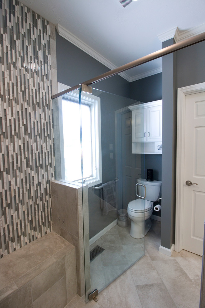 Example of a mid-sized transitional master gray tile and ceramic tile ceramic tile walk-in shower design with an undermount sink, raised-panel cabinets, white cabinets, granite countertops, a two-piece toilet and gray walls