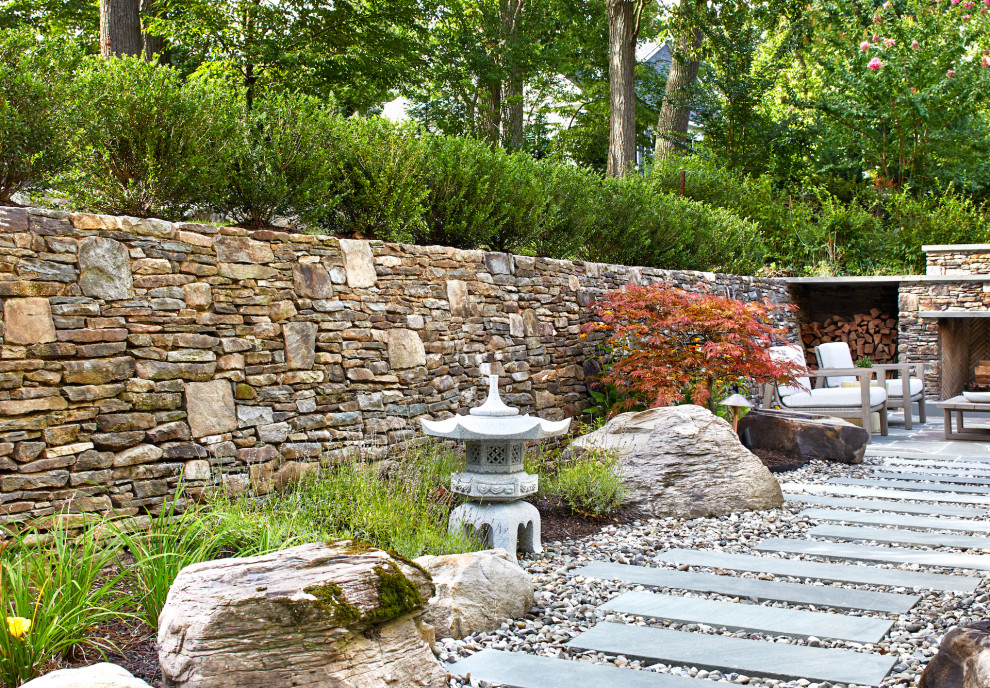 Large contemporary backyard full sun garden in DC Metro with a retaining wall and natural stone pavers for summer.