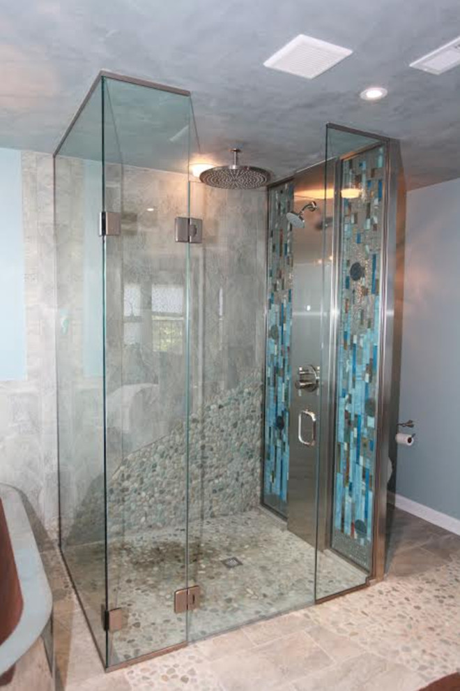 Design ideas for a large eclectic master bathroom in Philadelphia with flat-panel cabinets, dark wood cabinets, a freestanding tub, a curbless shower, a two-piece toilet, blue walls, pebble tile floors, a vessel sink, glass benchtops and a hinged shower door.
