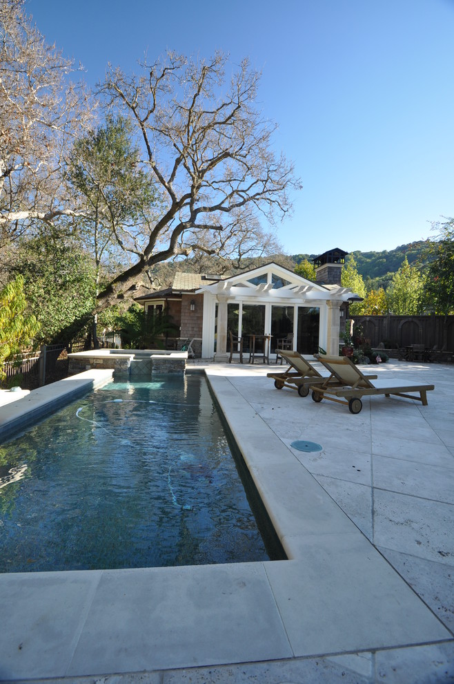 This is an example of a small eclectic backyard rectangular pool in San Francisco with a hot tub and natural stone pavers.