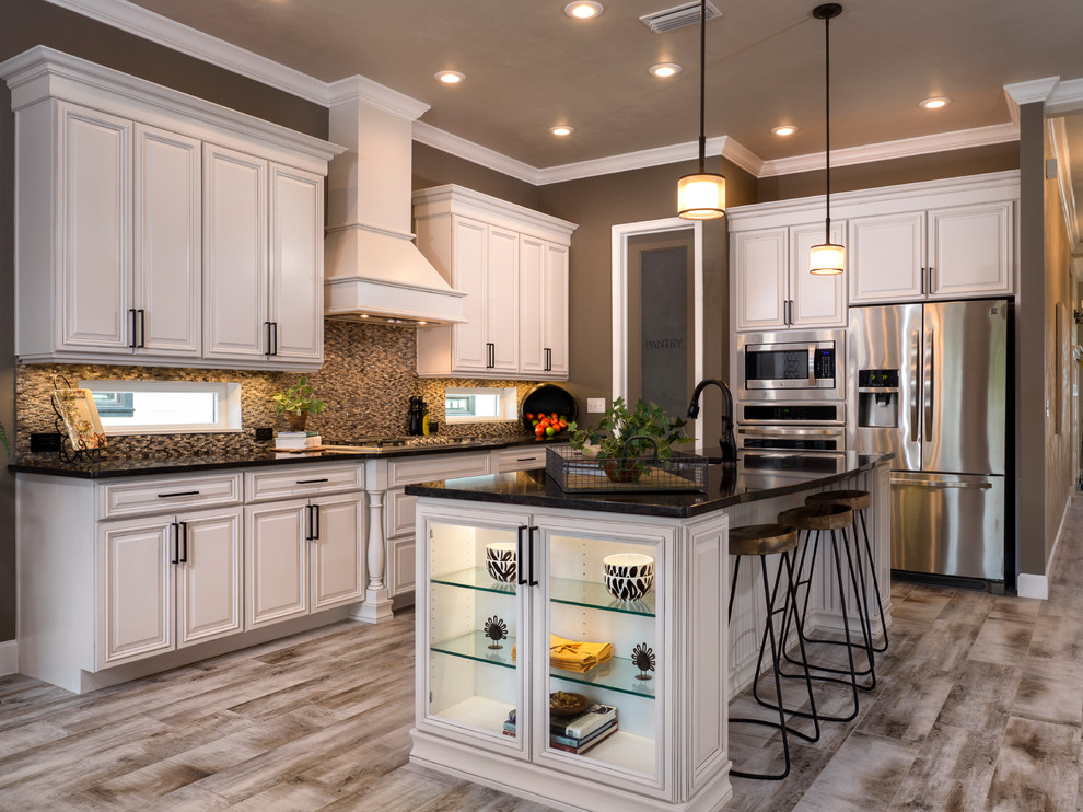 Mid-sized arts and crafts u-shaped eat-in kitchen in Miami with a double-bowl sink, beaded inset cabinets, white cabinets, quartzite benchtops, metallic splashback, stone tile splashback, stainless steel appliances, ceramic floors and with island.