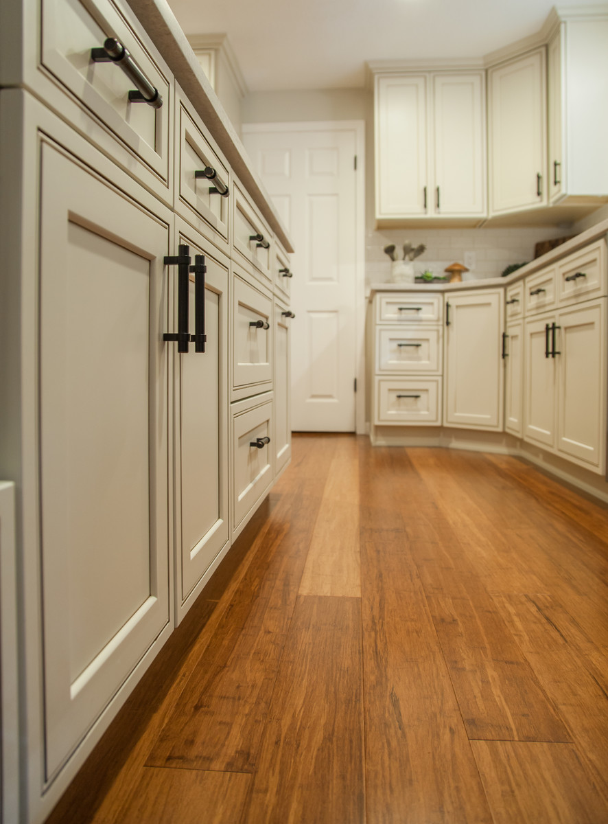 Inspiration for a mid-sized transitional l-shaped bamboo floor and brown floor eat-in kitchen remodel in Seattle with a double-bowl sink, recessed-panel cabinets, quartz countertops, white backsplash, ceramic backsplash, stainless steel appliances and an island
