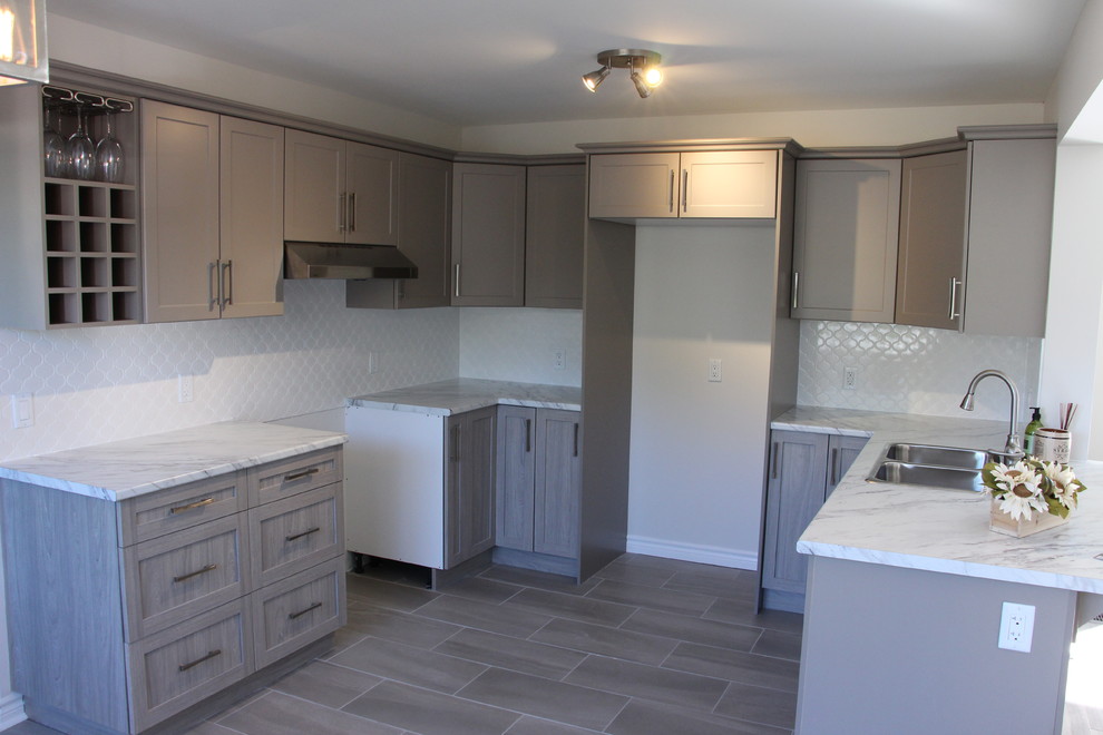 Eat-in kitchen - mid-sized rustic u-shaped porcelain tile eat-in kitchen idea in Toronto with a double-bowl sink, shaker cabinets, gray cabinets, laminate countertops, white backsplash, porcelain backsplash and a peninsula
