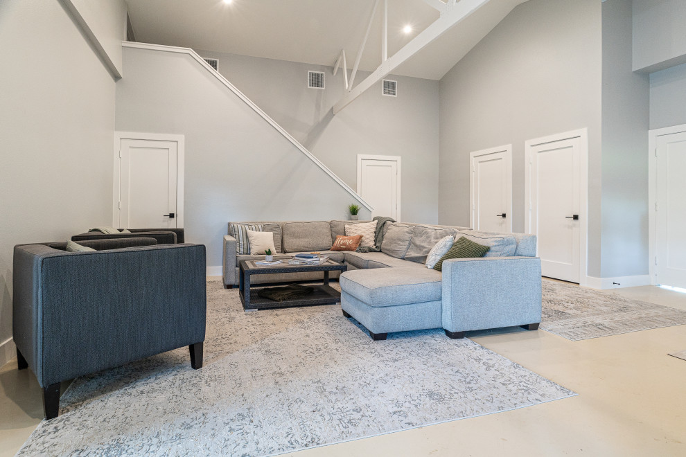 Design ideas for a large transitional loft-style living room in Dallas with grey walls, concrete floors, beige floor and vaulted.