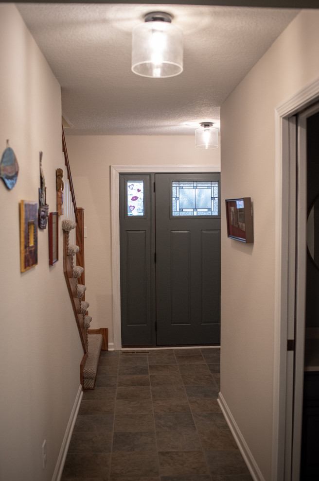 Inspiration for a mid-sized transitional slate floor and multicolored floor single front door remodel with white walls and a gray front door