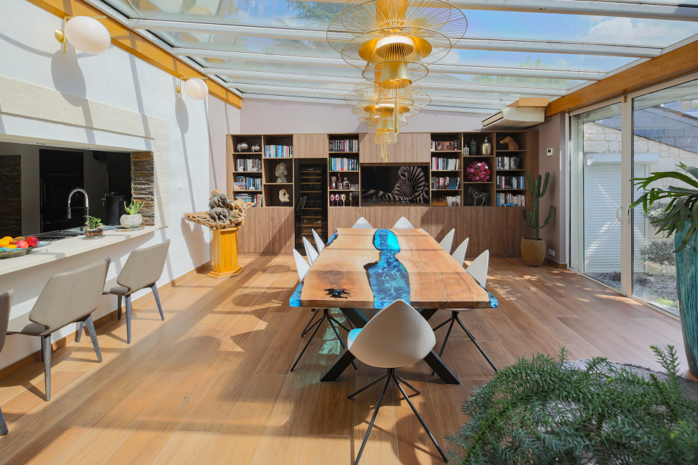 Immagine di una grande sala da pranzo aperta verso il soggiorno minimal con pareti rosa, pavimento con piastrelle in ceramica, pavimento marrone e travi a vista