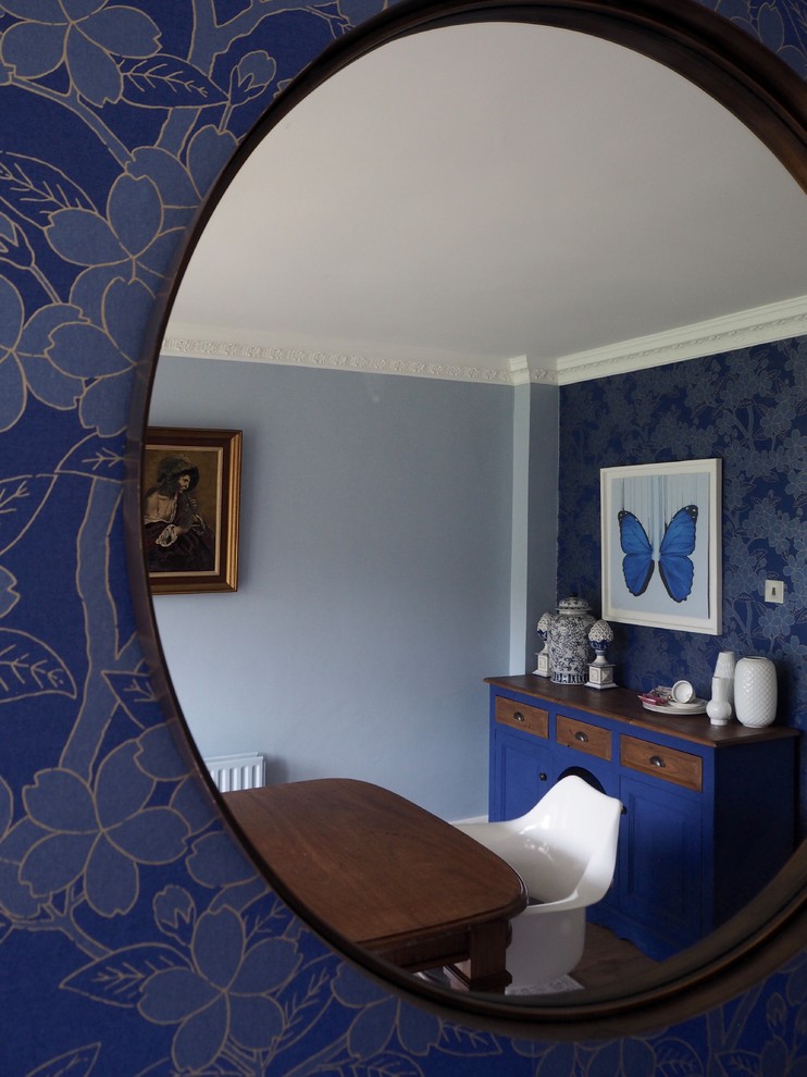 Inspiration for a mid-sized eclectic separate dining room in Surrey with blue walls, laminate floors and brown floor.