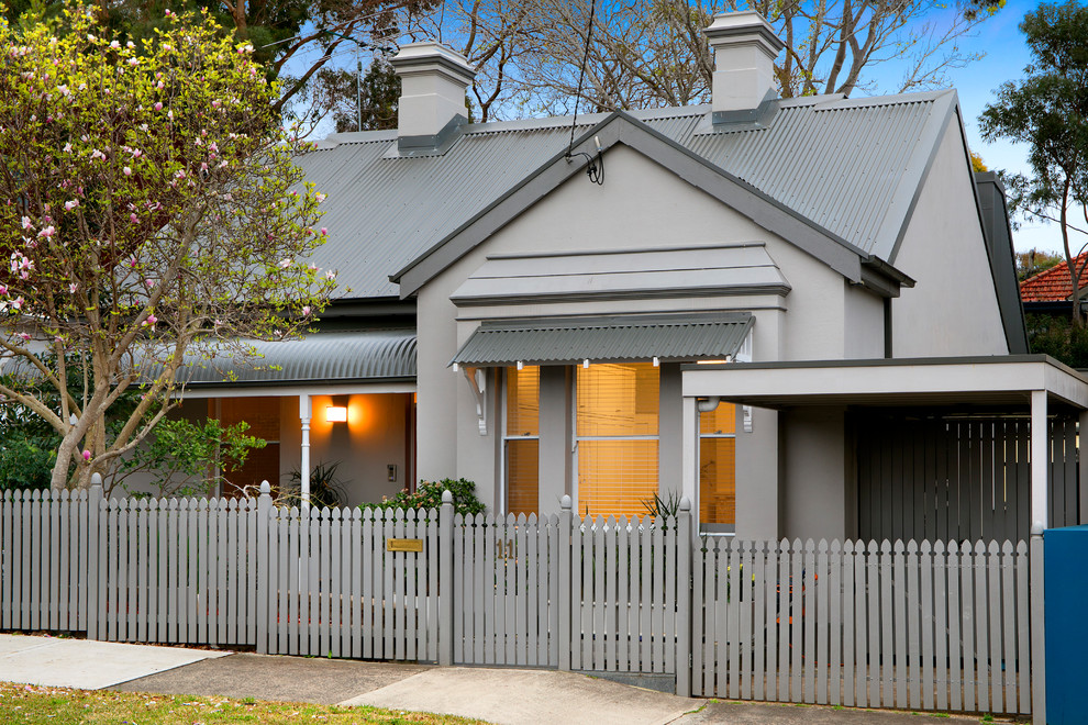Transitional one-storey grey house exterior in Sydney with a metal roof and a gable roof.