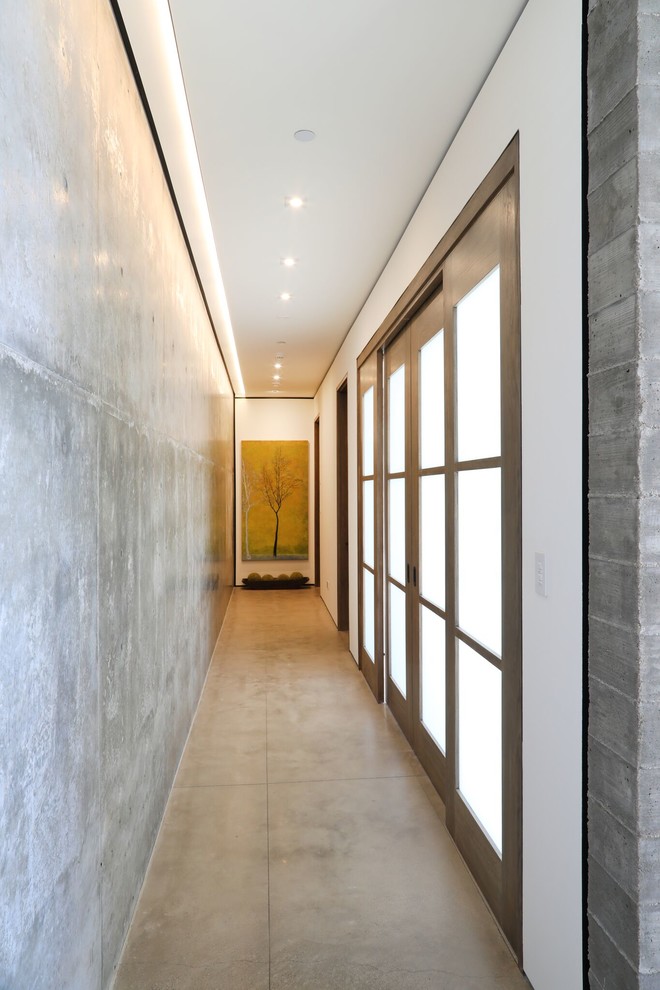 This is an example of a large contemporary hallway in Orange County with white walls, ceramic floors and white floor.