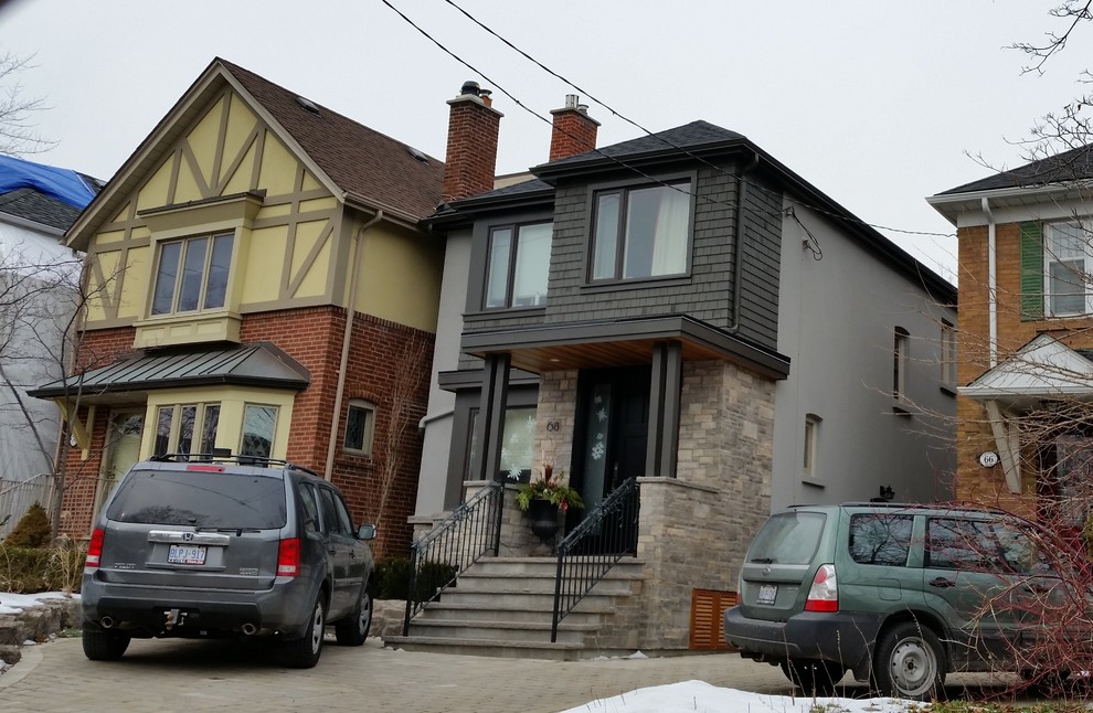 Photo of a mid-sized transitional two-storey grey exterior in Toronto with wood siding and a hip roof.