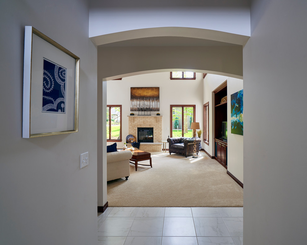 Photo of a large transitional open concept family room in Other with white walls, carpet, a standard fireplace, a brick fireplace surround and a built-in media wall.