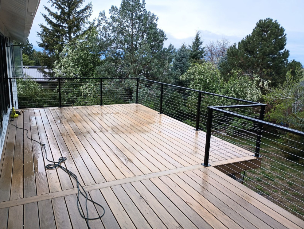 Inspiration for a mid-sized contemporary deck in Boise with with skirting and cable railing.