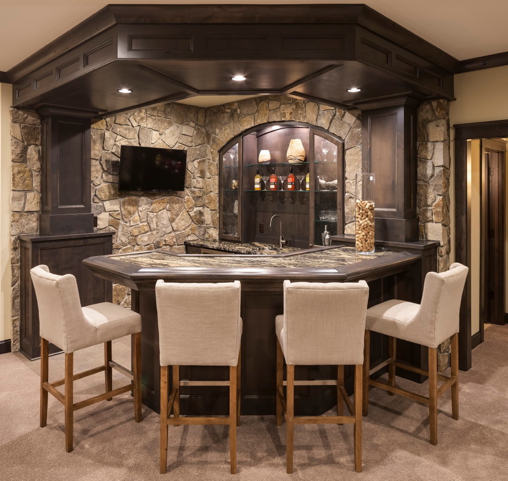 Photo of a mid-sized country seated home bar in Minneapolis with raised-panel cabinets, dark wood cabinets, granite benchtops, brown splashback, stone tile splashback and beige floor.