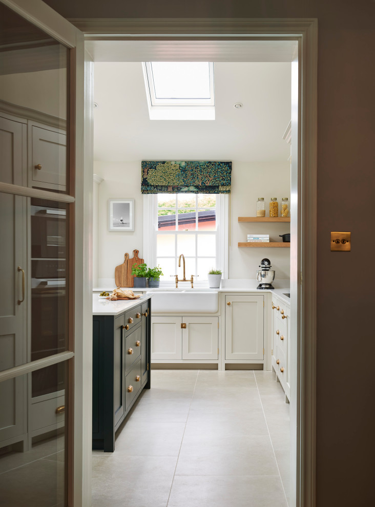 Idées déco pour une cuisine américaine classique avec un évier de ferme, un placard à porte shaker, des portes de placards vertess, un plan de travail en quartz, une crédence blanche, un électroménager noir, un sol en carrelage de porcelaine, îlot, un sol gris, un plan de travail blanc et un plafond voûté.