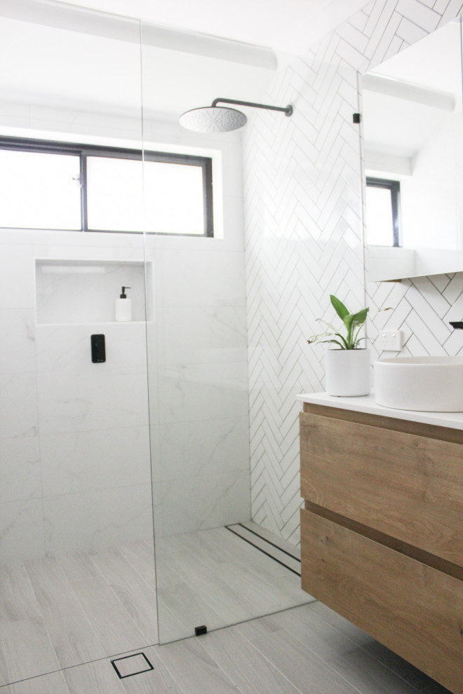 Photo of a mid-sized modern master bathroom in Perth with open cabinets, dark wood cabinets, an open shower, a one-piece toilet, white tile, ceramic tile, white walls, porcelain floors, a vessel sink, engineered quartz benchtops, grey floor, an open shower, white benchtops, a single vanity and a floating vanity.
