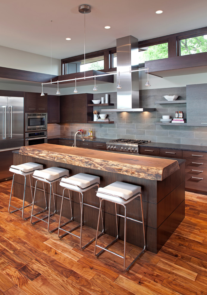 Inspiration for a contemporary l-shaped kitchen in Minneapolis with flat-panel cabinets, dark wood cabinets, grey splashback and stainless steel appliances.