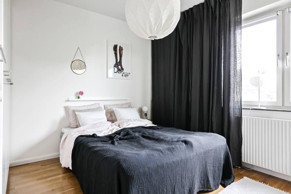 Mid-sized scandinavian master bedroom in Gothenburg with medium hardwood floors and brown floor.