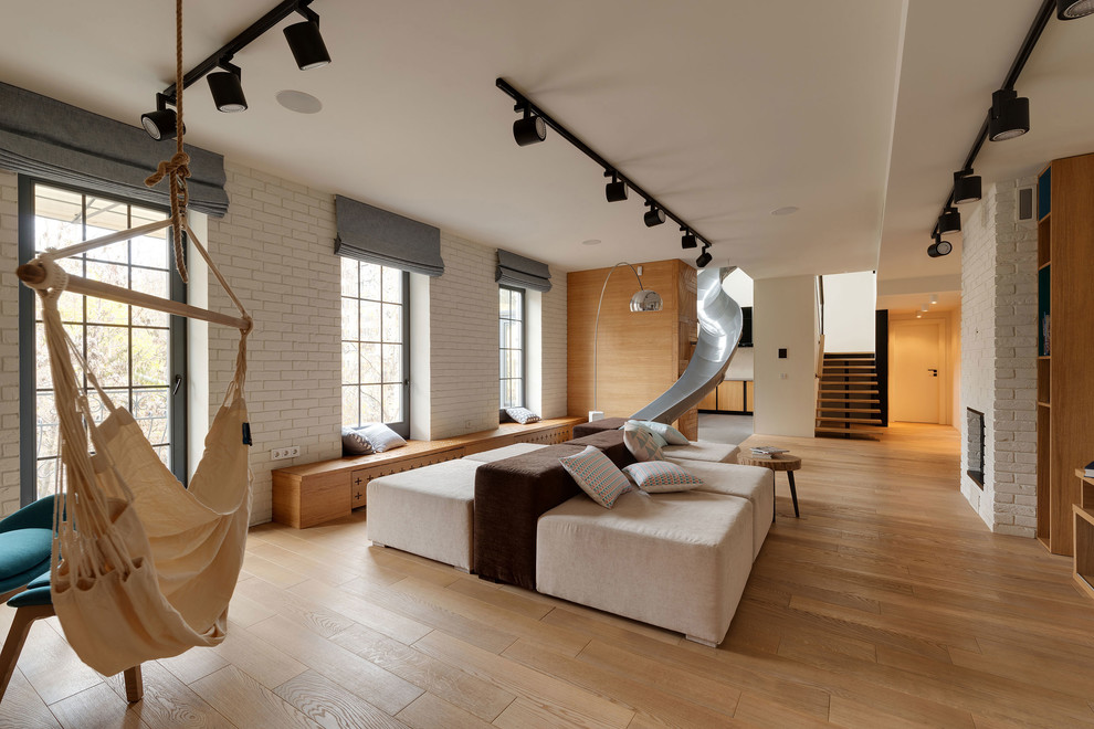 Contemporary gender-neutral kids' room in Other with white walls and light hardwood floors.