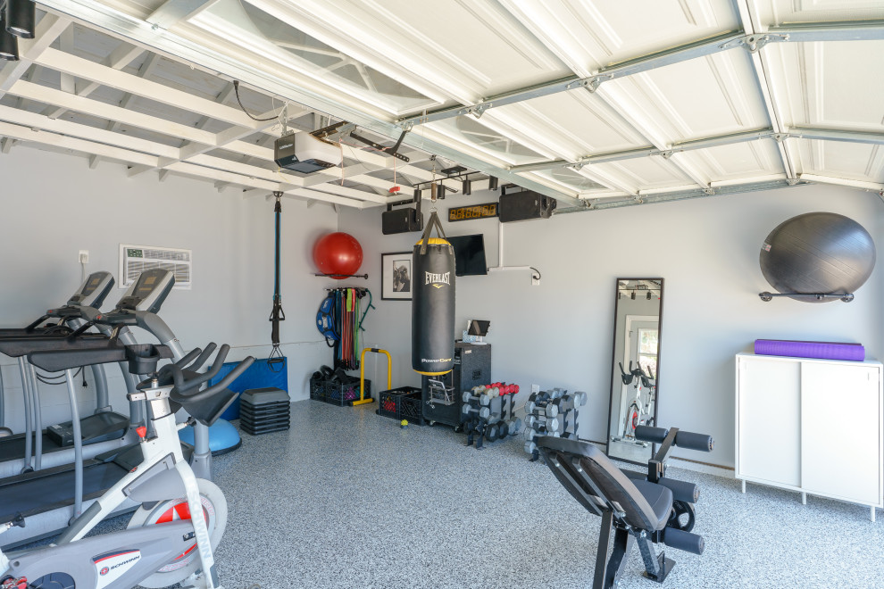 Idée de décoration pour une salle de sport minimaliste de taille moyenne avec un mur gris, sol en béton ciré, un sol multicolore et poutres apparentes.