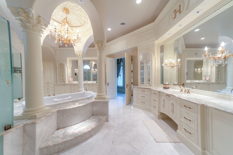 Expansive traditional master bathroom in Houston with an undermount sink, a freestanding tub, a double shower, white tile, stone tile, white walls and marble floors.