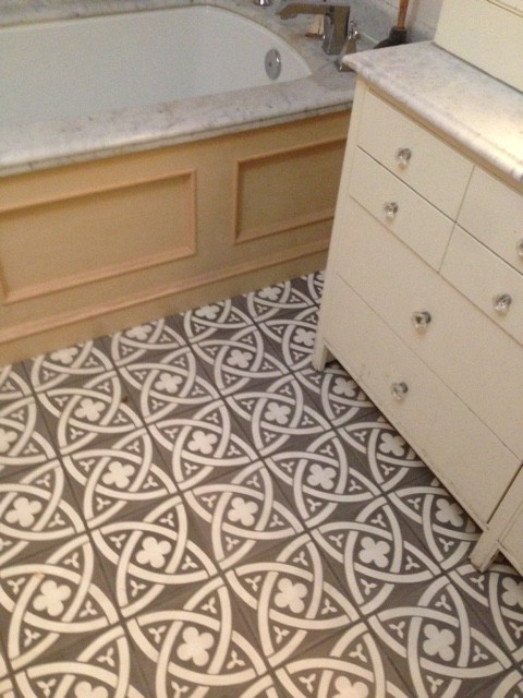 Inspiration for a mid-sized transitional 3/4 gray tile, white tile and stone tile mosaic tile floor corner bathtub remodel in Calgary with flat-panel cabinets, white cabinets, a one-piece toilet, white walls, a drop-in sink and soapstone countertops