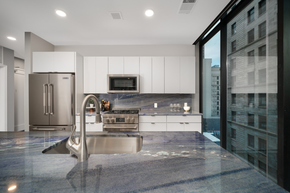 Moderne Küche mit Unterbauwaschbecken, flächenbündigen Schrankfronten, Quarzit-Arbeitsplatte, Küchenrückwand in Blau, Kücheninsel und blauer Arbeitsplatte in Sonstige