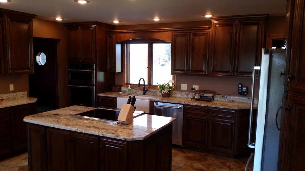 Large elegant u-shaped ceramic tile kitchen photo with a farmhouse sink, raised-panel cabinets, medium tone wood cabinets, granite countertops, stainless steel appliances and two islands
