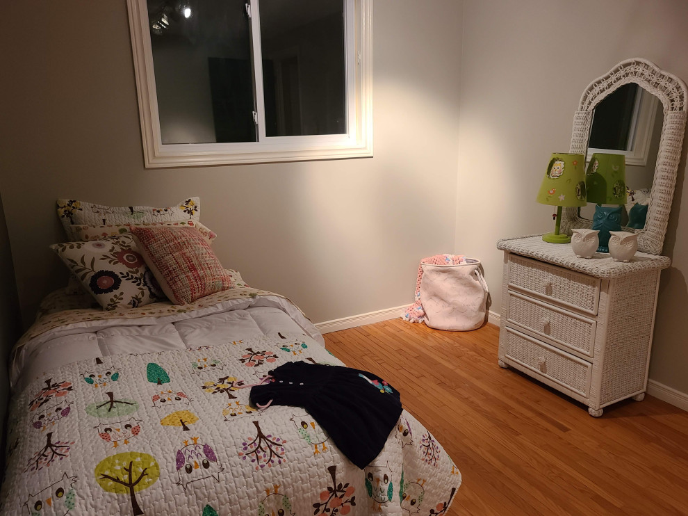 Inspiration for a small modern toddler’s room for girls in Other with grey walls and light hardwood flooring.