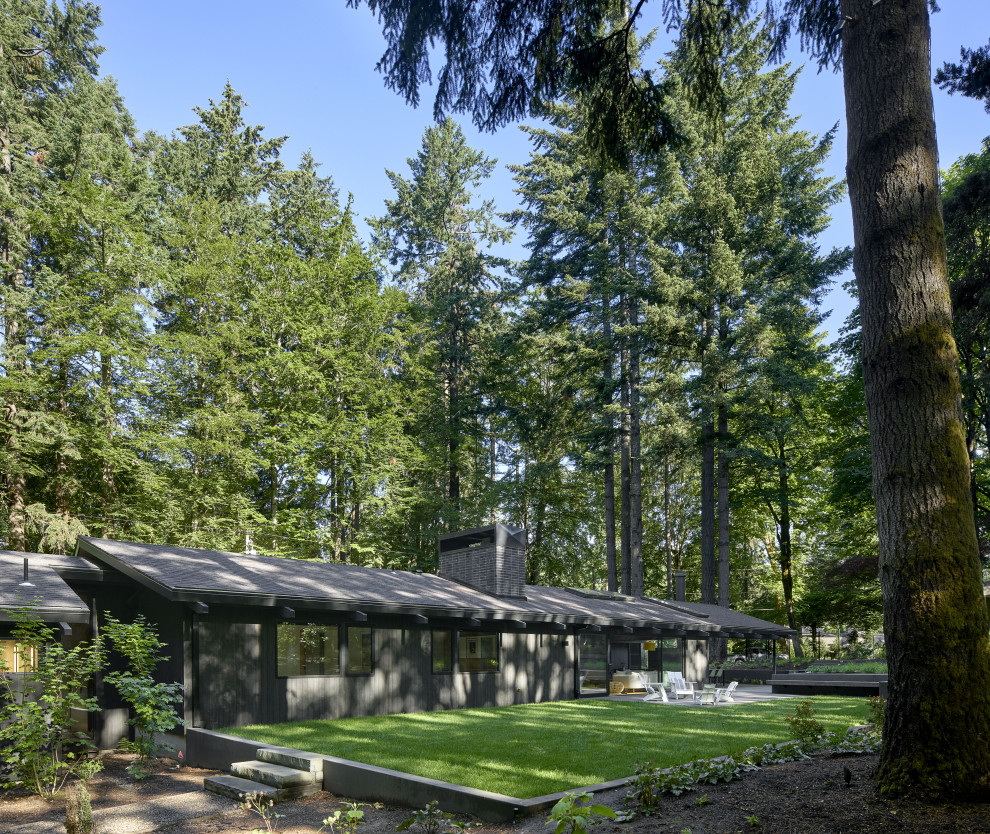 Inspiration for a large 1960s black one-story wood exterior home remodel in Portland with a shingle roof and a black roof