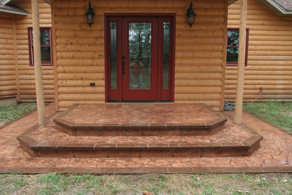 Mid-sized mountain style stamped concrete front porch idea with a roof extension