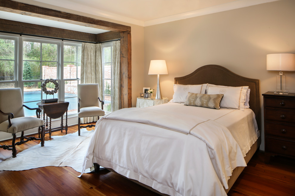 This is an example of a large traditional master bedroom in New Orleans with beige walls, medium hardwood floors and brown floor.