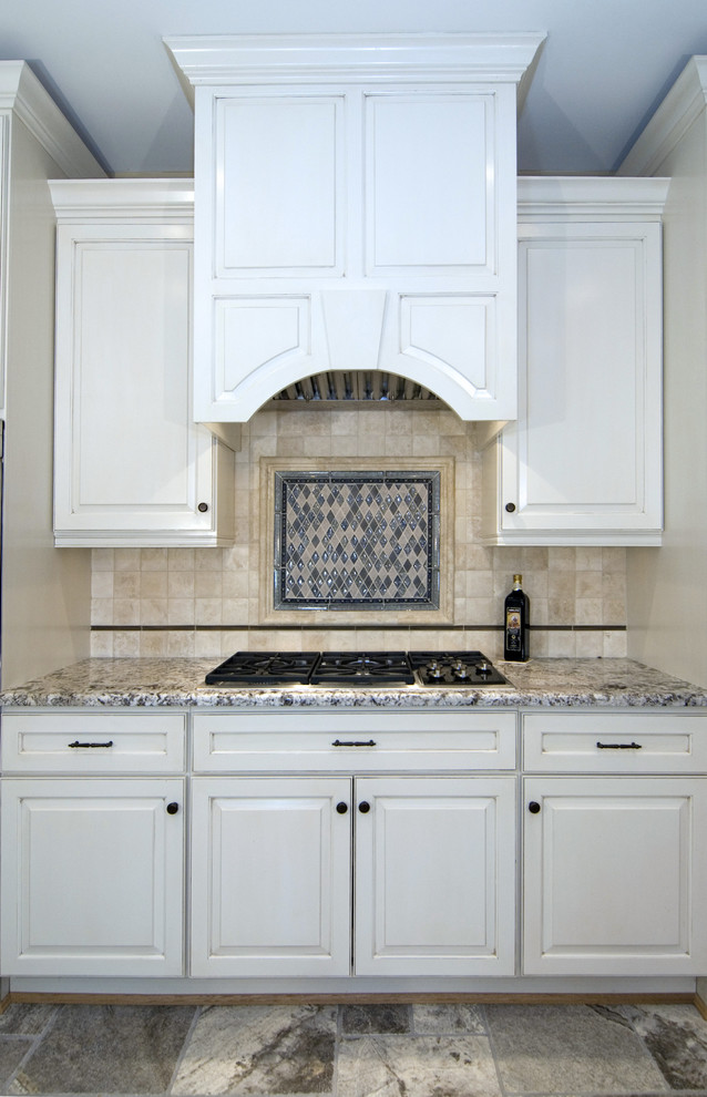 Traditional kitchen in DC Metro with white cabinets and travertine splashback.