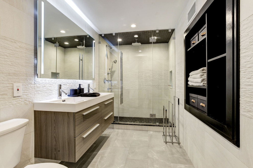 На фото: главная ванная комната среднего размера в стиле модернизм с плоскими фасадами, коричневыми фасадами, душем в нише, раздельным унитазом, бежевой плиткой, керамогранитной плиткой, белыми стенами, светлым паркетным полом, подвесной раковиной, столешницей из искусственного камня, бежевым полом, душем с распашными дверями, белой столешницей, нишей, тумбой под две раковины, подвесной тумбой и кессонным потолком