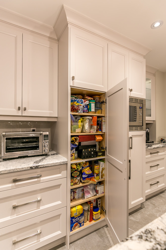 Large transitional gray floor enclosed kitchen photo in Toronto with an undermount sink, recessed-panel cabinets, white cabinets, quartz countertops, white backsplash, ceramic backsplash, stainless steel appliances and an island