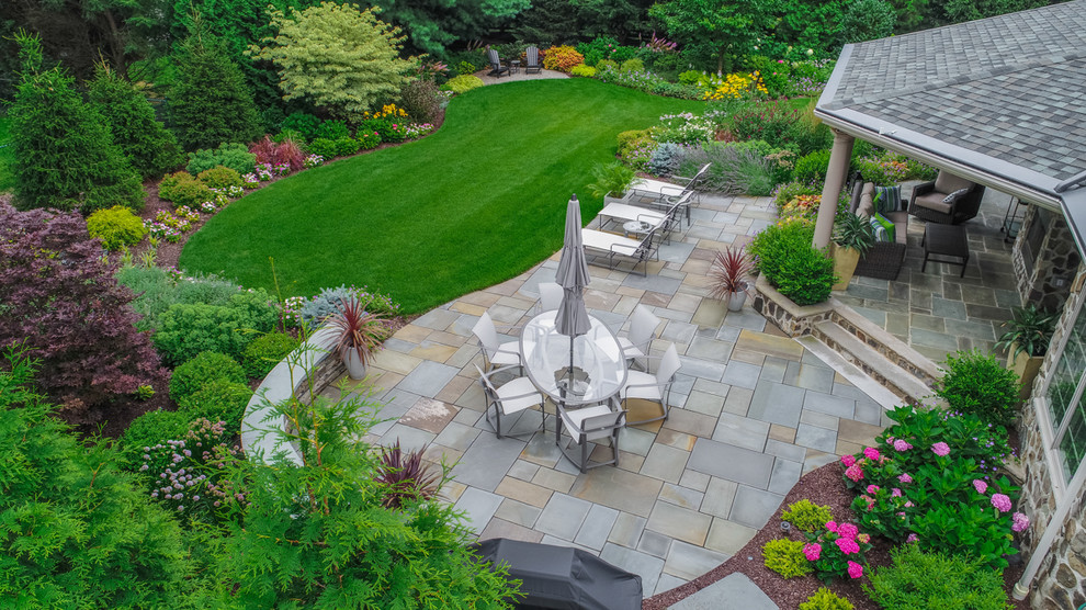 Photo of a traditional backyard garden with natural stone pavers.