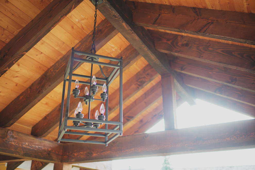Inspiration for a large rustic backyard balcony deck remodel with a roof extension
