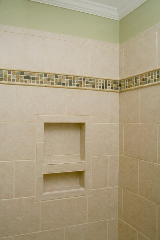This is an example of a mid-sized transitional master bathroom in Raleigh with raised-panel cabinets, medium wood cabinets, an alcove shower, a two-piece toilet, beige tile, cement tile, green walls, cement tiles, an undermount sink, granite benchtops, multi-coloured floor, a hinged shower door and green benchtops.