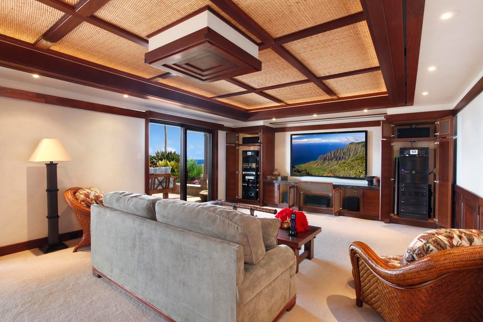 Design ideas for a large tropical enclosed home theatre in Hawaii with beige walls, carpet, a projector screen and beige floor.