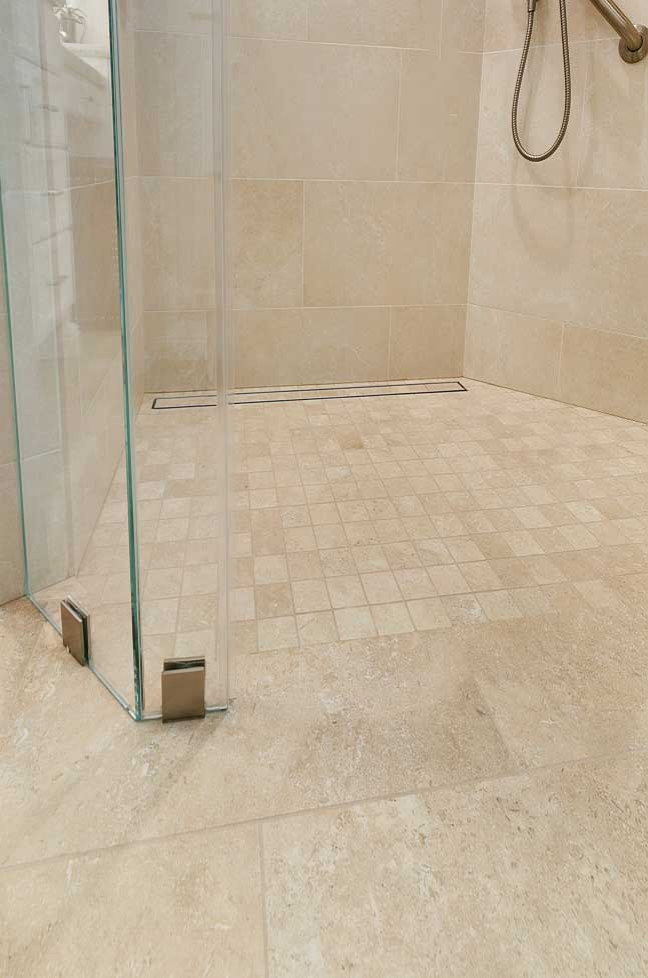 Photo of a large transitional master bathroom in San Francisco with recessed-panel cabinets, white cabinets, an alcove shower, a two-piece toilet, beige tile, porcelain tile, beige walls, porcelain floors, an undermount sink, engineered quartz benchtops, beige floor, a hinged shower door, beige benchtops, a laundry, a double vanity and a built-in vanity.