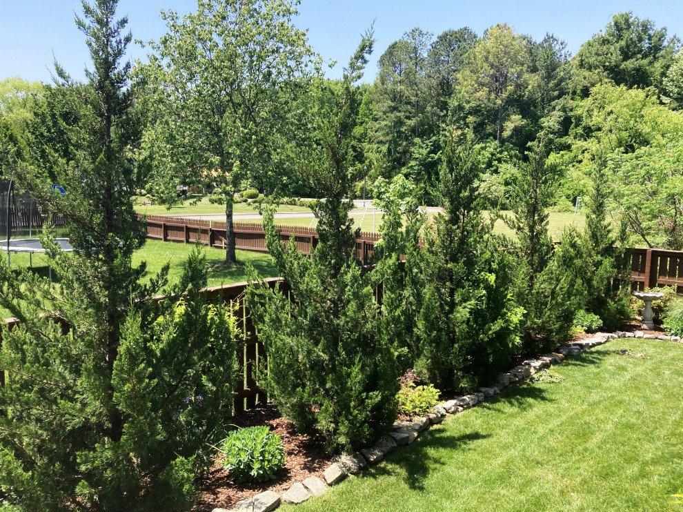 This is an example of a large traditional backyard flower bed.
