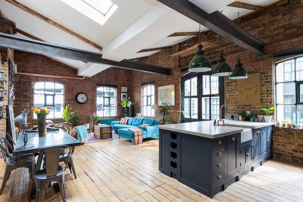 Inspiration for a large industrial open concept living room in London with brown floor and light hardwood floors.