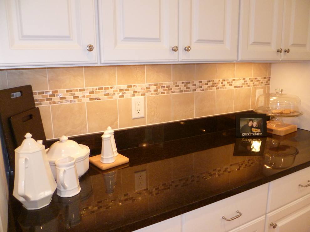 Mid-sized elegant l-shaped medium tone wood floor enclosed kitchen photo in Cedar Rapids with an undermount sink, shaker cabinets, white cabinets, granite countertops, white backsplash, ceramic backsplash, stainless steel appliances and an island