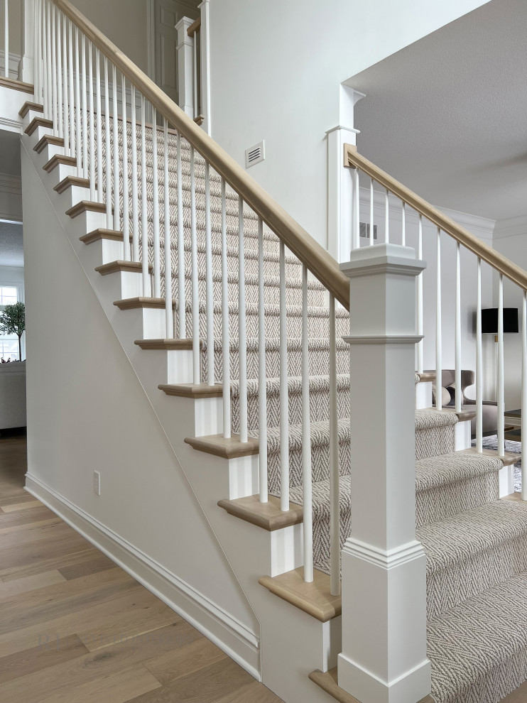 This is an example of a large classic carpeted straight wood railing staircase in Other with carpeted risers and panelled walls.