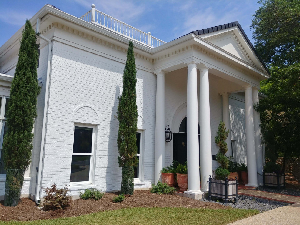 Expansive and white classic two floor brick detached house in Austin with a pitched roof.