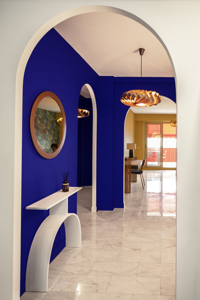 Inspiration pour une entrée design en bois avec un mur bleu et un sol en marbre.
